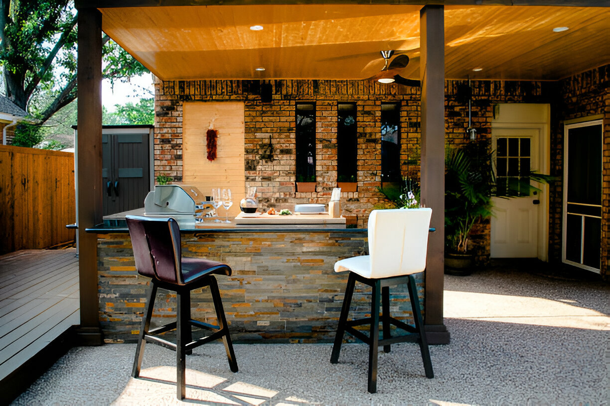 Outdoor kitchen with stainless steel grill and rustic stone countertop