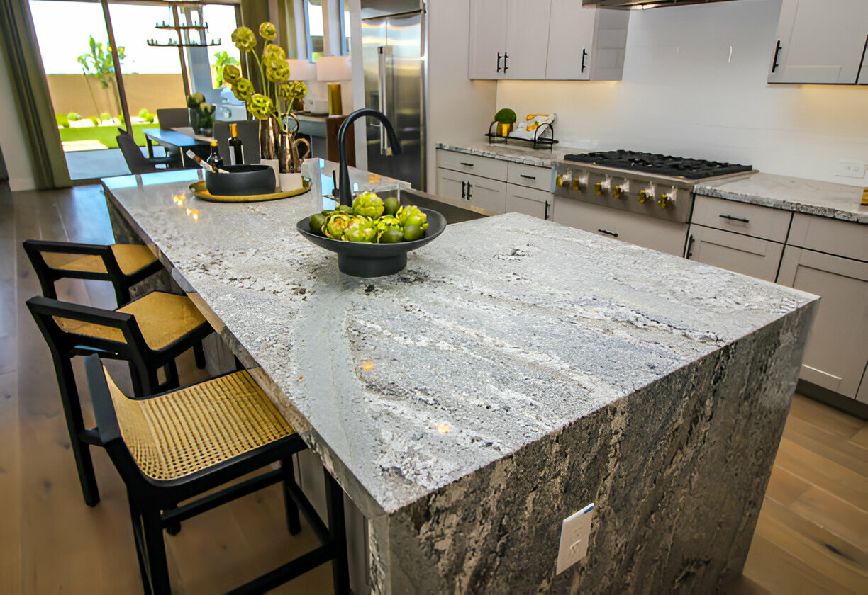 Modern kitchen featuring a striking granite waterfall island and sleek white cabinetry 