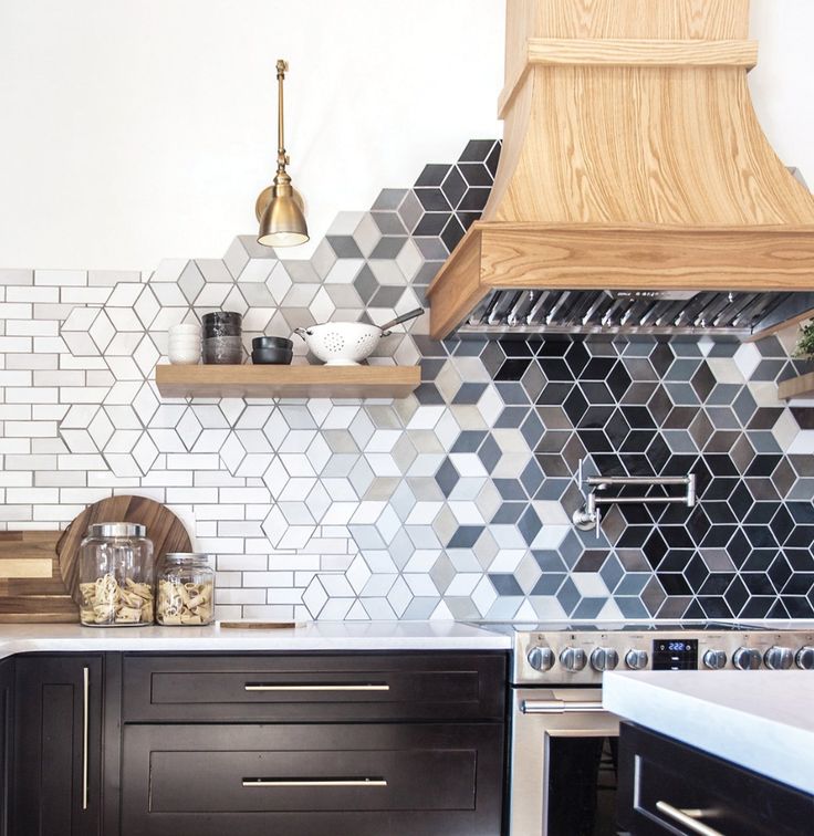 Kitchen with a creative geometric backsplash transitioning from white subway tiles to 3D cube patterns in gray, white, and black tones.