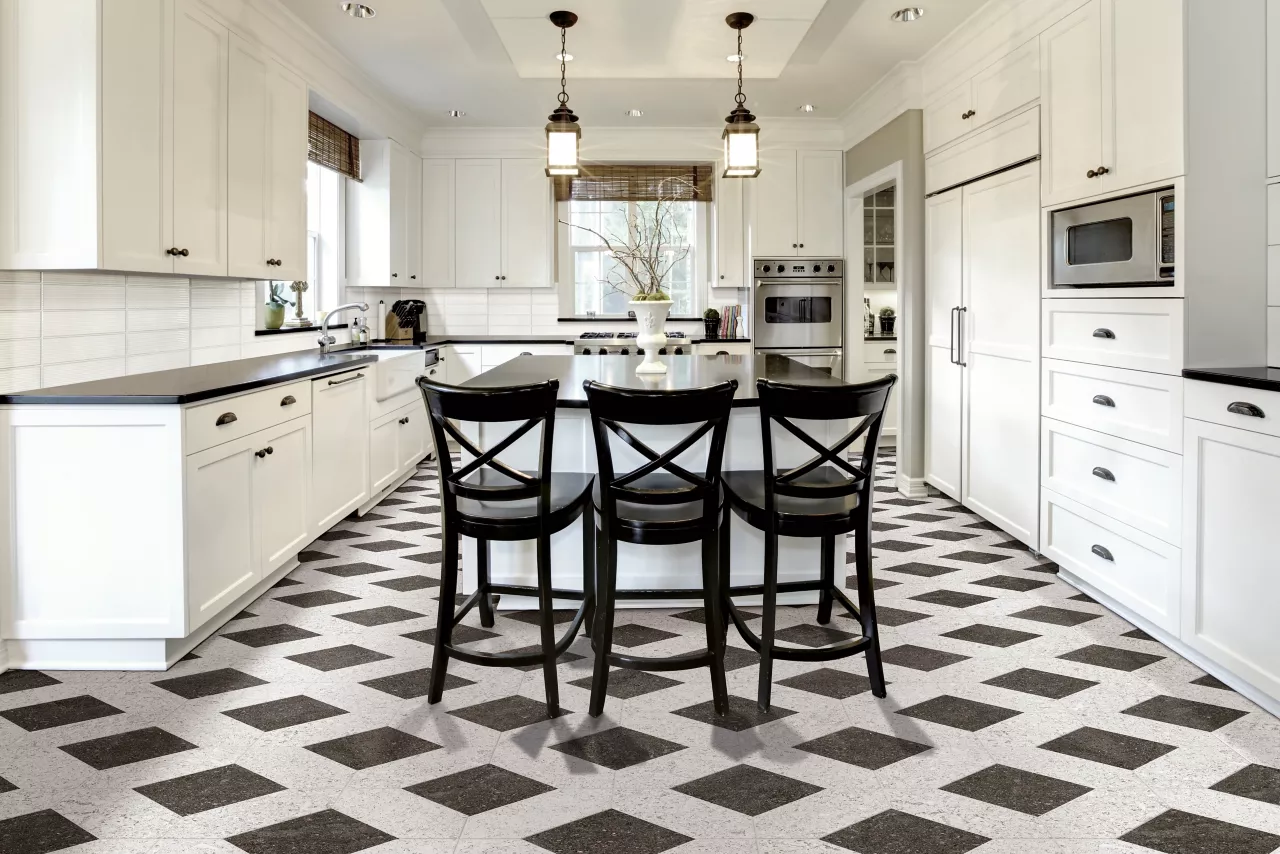 Elegant white kitchen with black countertops and bold black-and-white diamond pattern flooring.