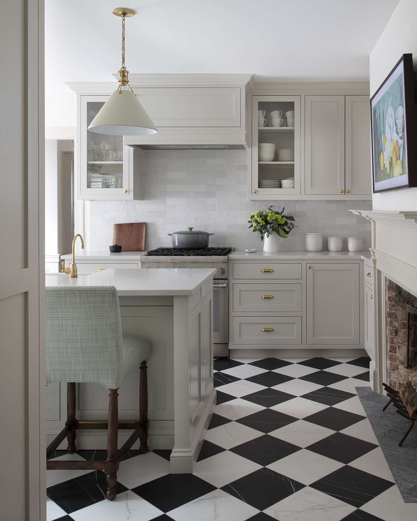 Elegant kitchen with white cabinetry and black and white checkered tile flooring.