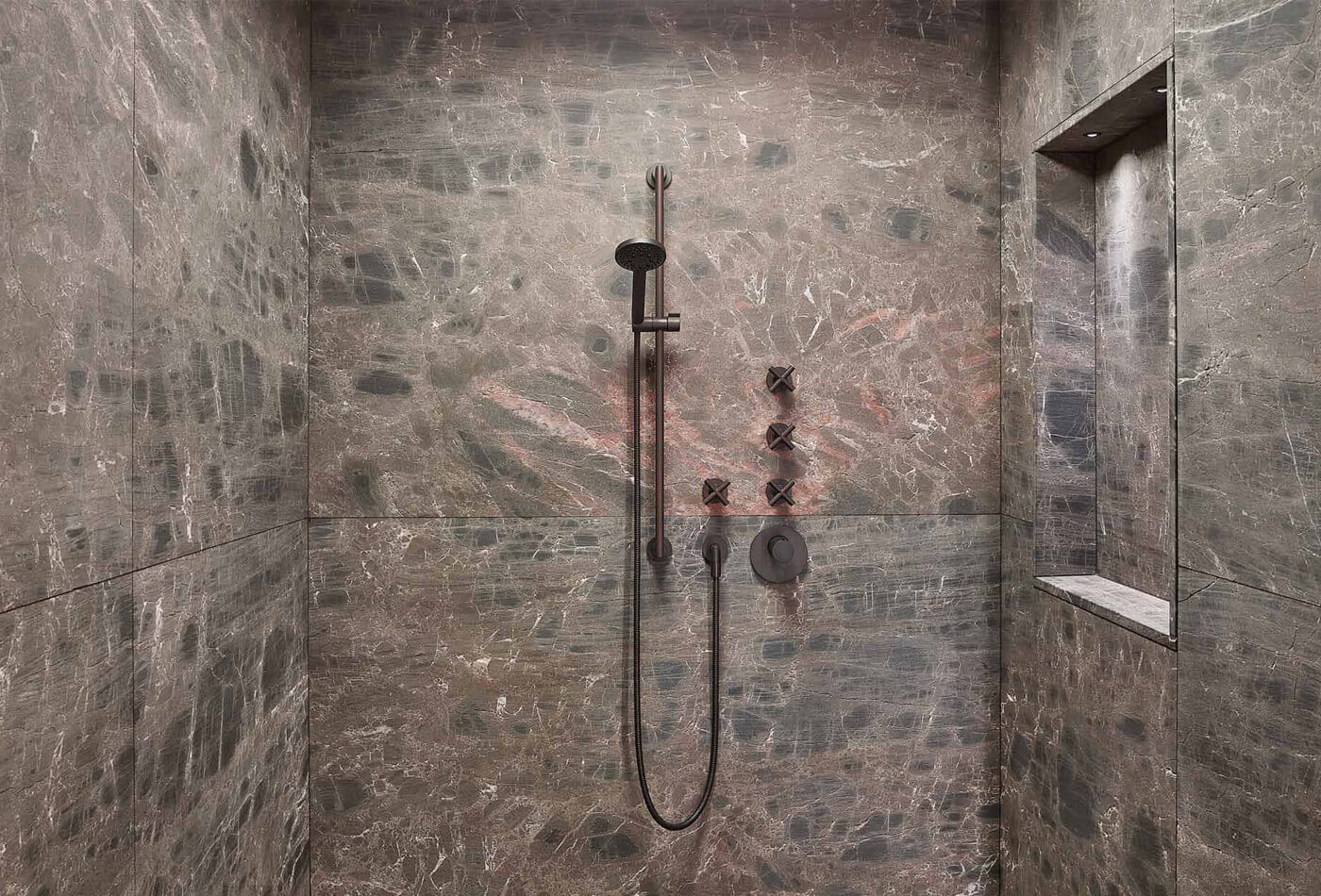 Granite stone shower walls featuring matte black handheld showerhead and controls with built-in niche