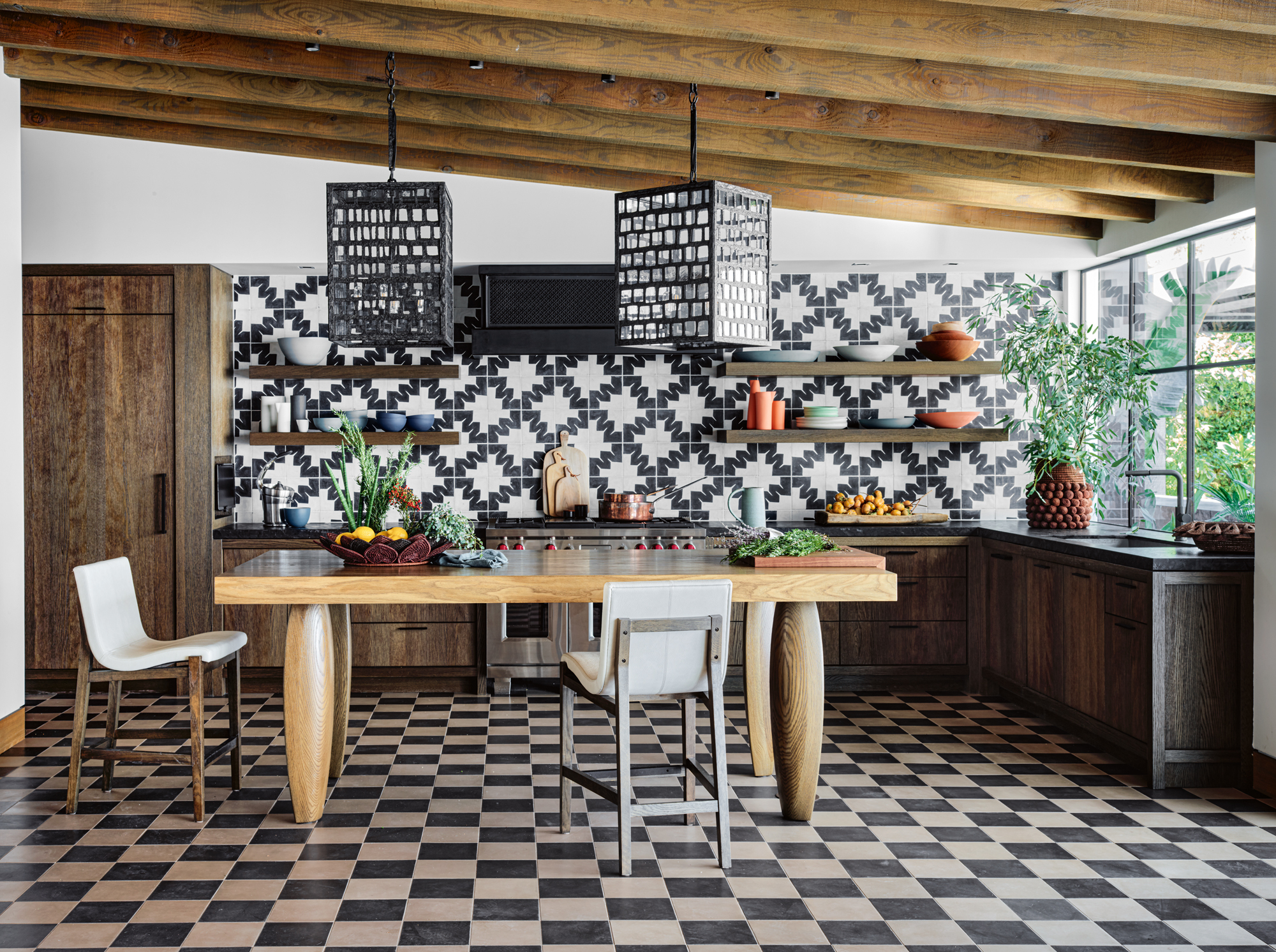 Rustic-style kitchen with wooden cabinetry, black and white geometric tile backsplash, and checkered tile flooring.
