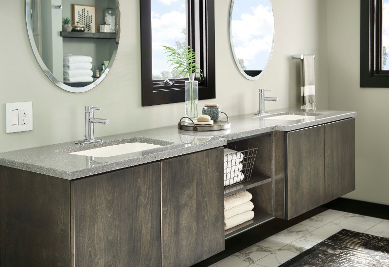 Contemporary floating bathroom vanity with dual sinks, gray quartz countertop, and dark wood cabinetry under round mirrors