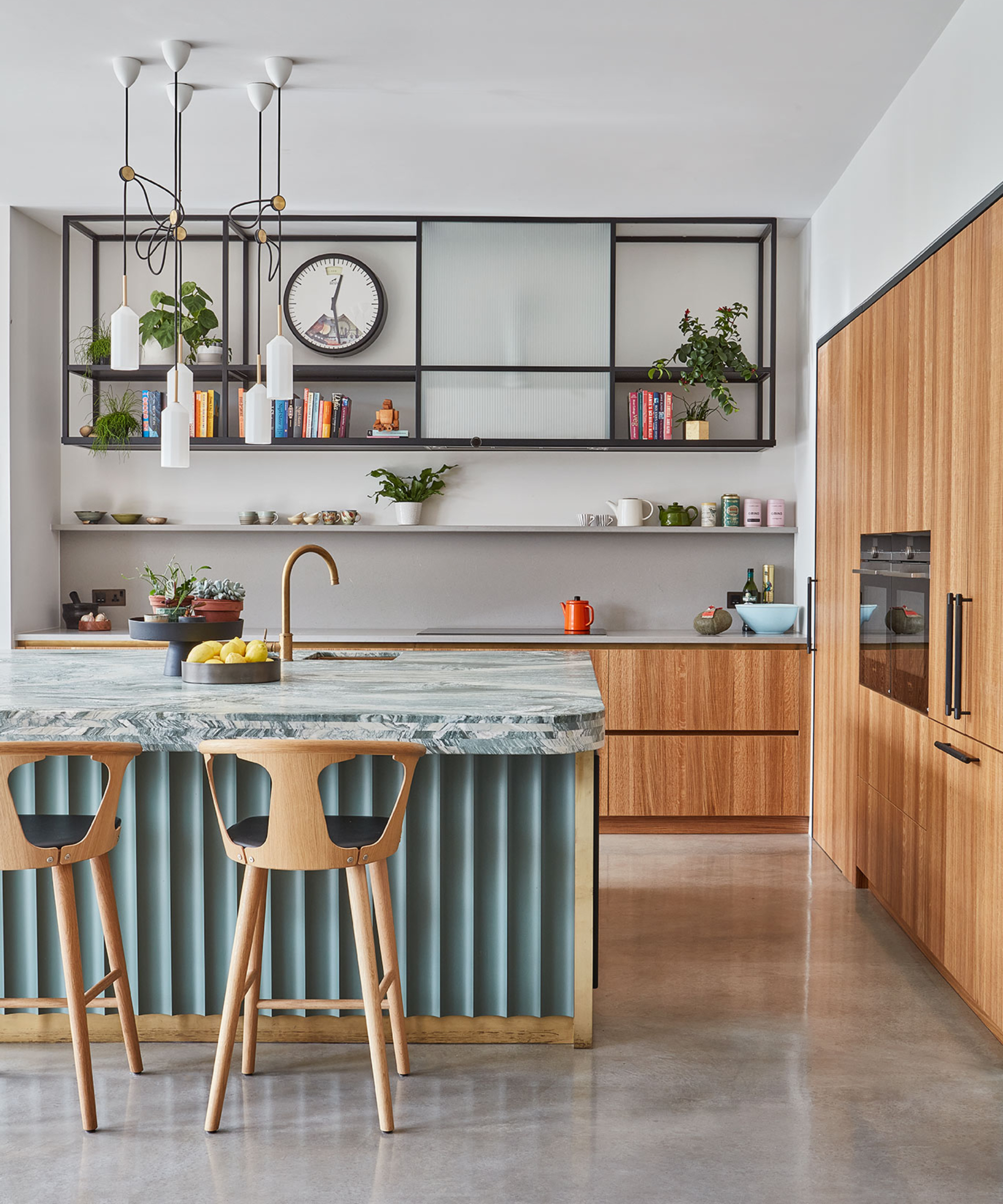 Contemporary kitchen with a fluted blue island, waterfall marble countertop, wooden cabinetry, open shelving, and modern pendant lights.
