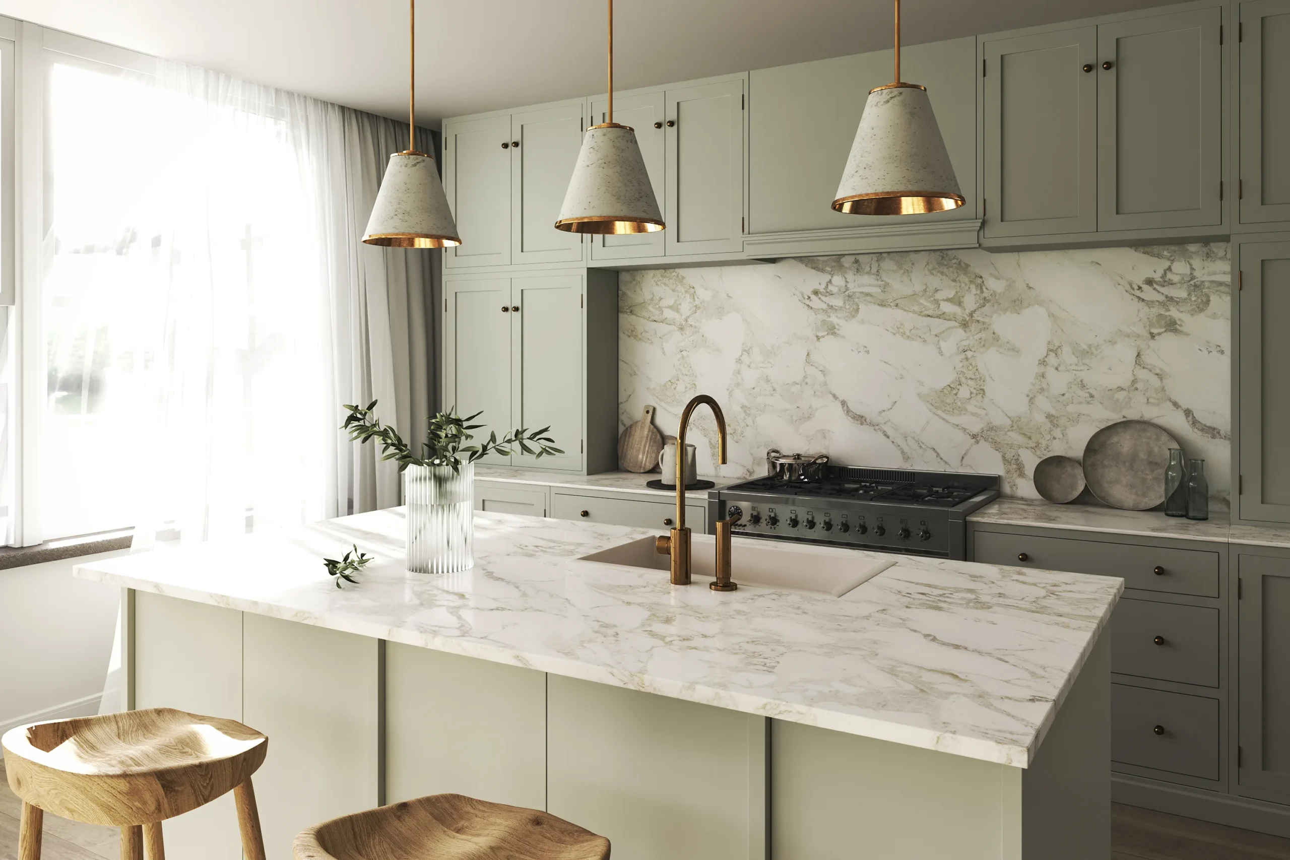 Modern kitchen with light sage green cabinets, marble countertops and backsplash, and gold pendant lights.