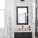 Modern black and white bathroom with brass fixtures and minimalist design.