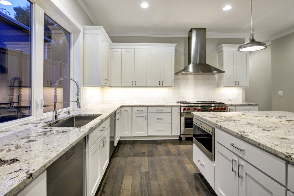 Modern kitchen with white shaker cabinets, stainless steel appliances, and granite countertops.