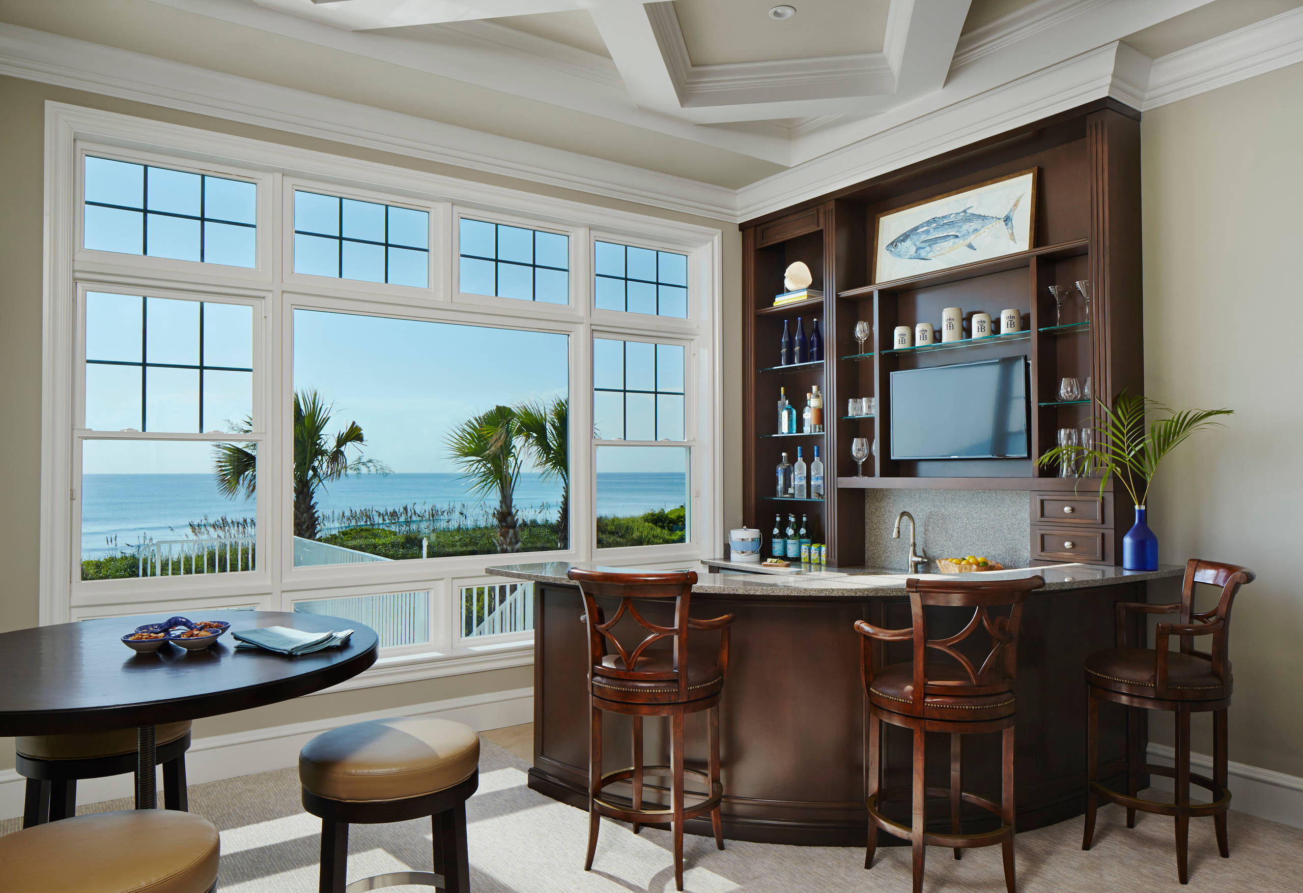 coastal home bar with ocean view, dark wood cabinetry, and elegant bar stools