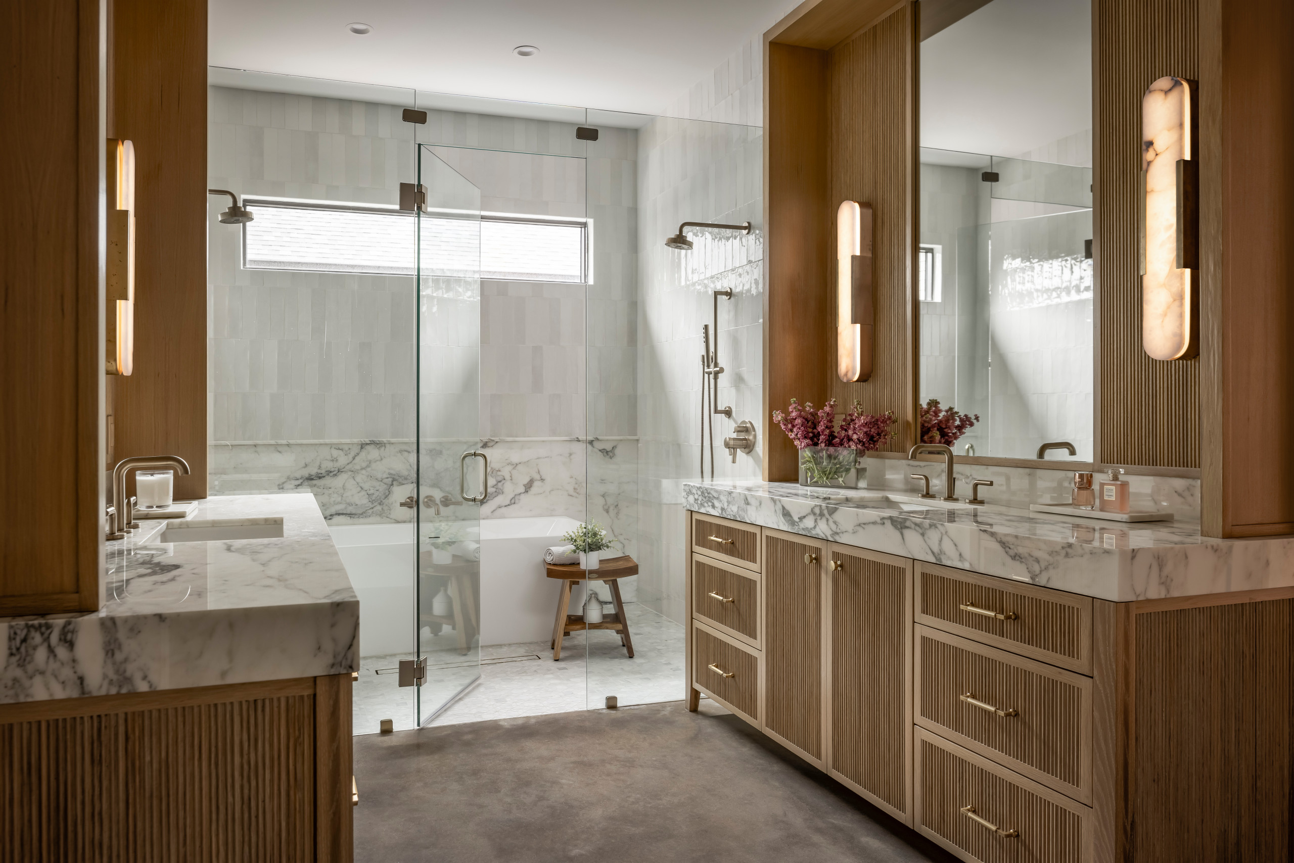 Modern bathroom with marble countertops and a glass shower.