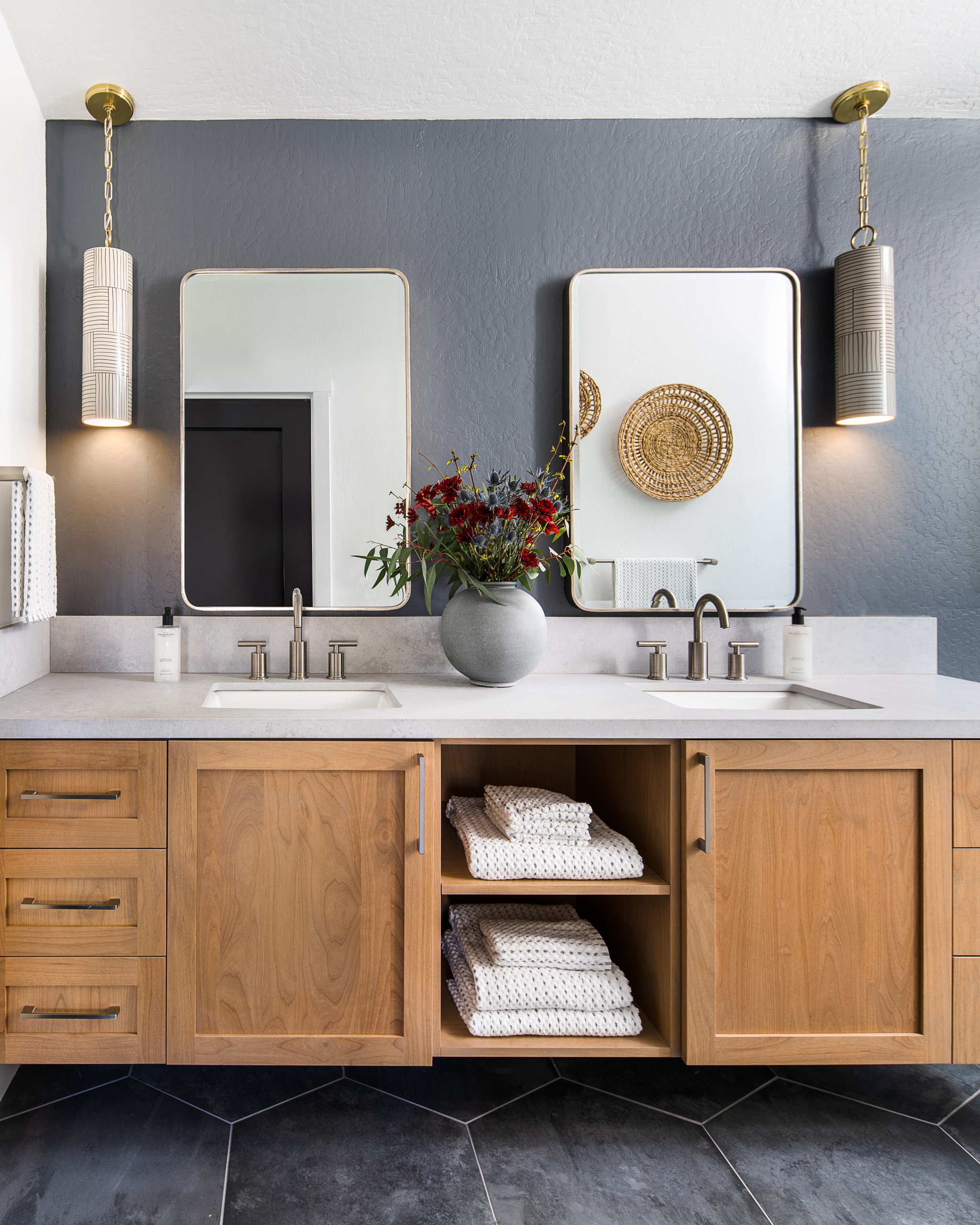 Modern bathroom vanity with wood cabinets, dual sinks, and decorative accents