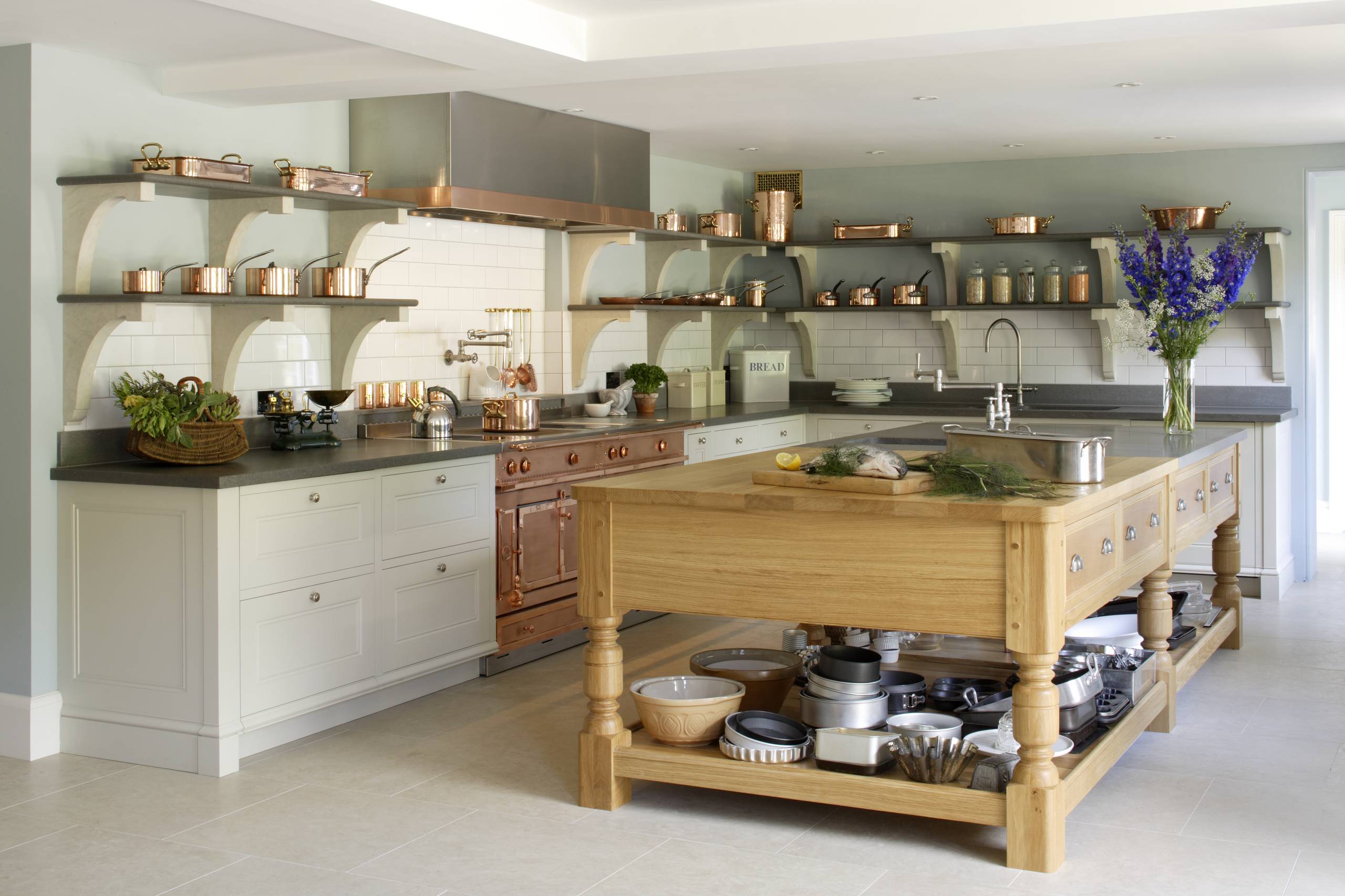 Traditional kitchen with copper cookware, large wooden island, and open shelving