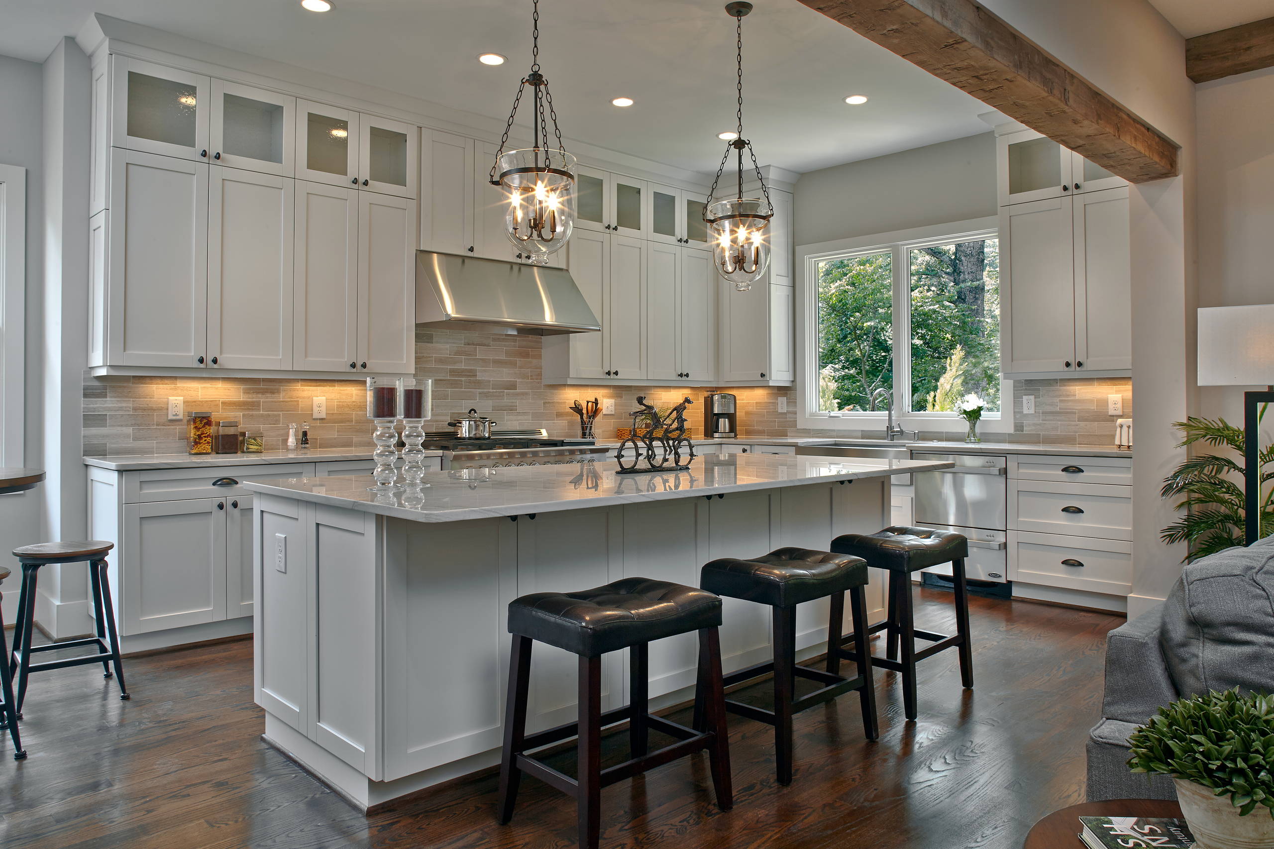 Traditional kitchen with white cabinets, large island, and pendant lighting.