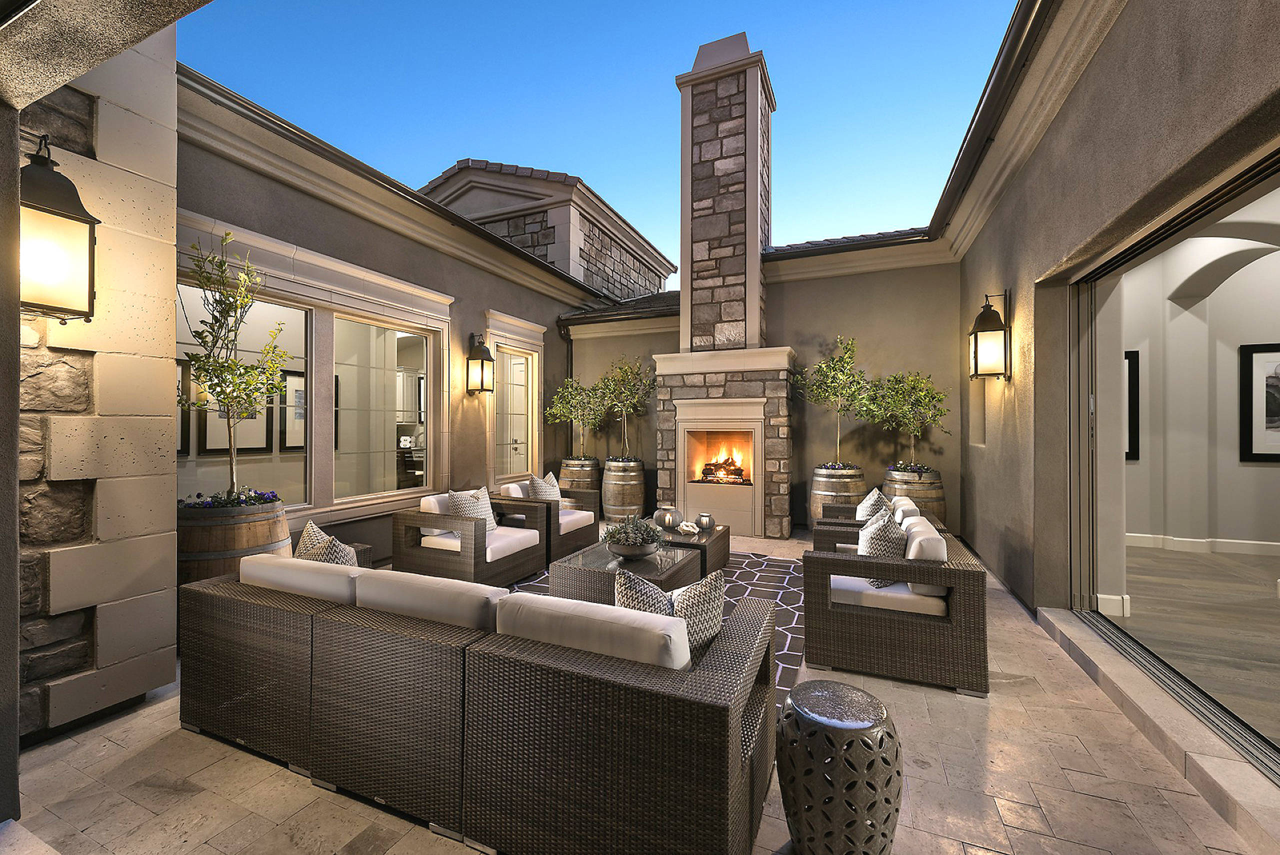 Luxurious outdoor living space with stone fireplace and wicker furniture