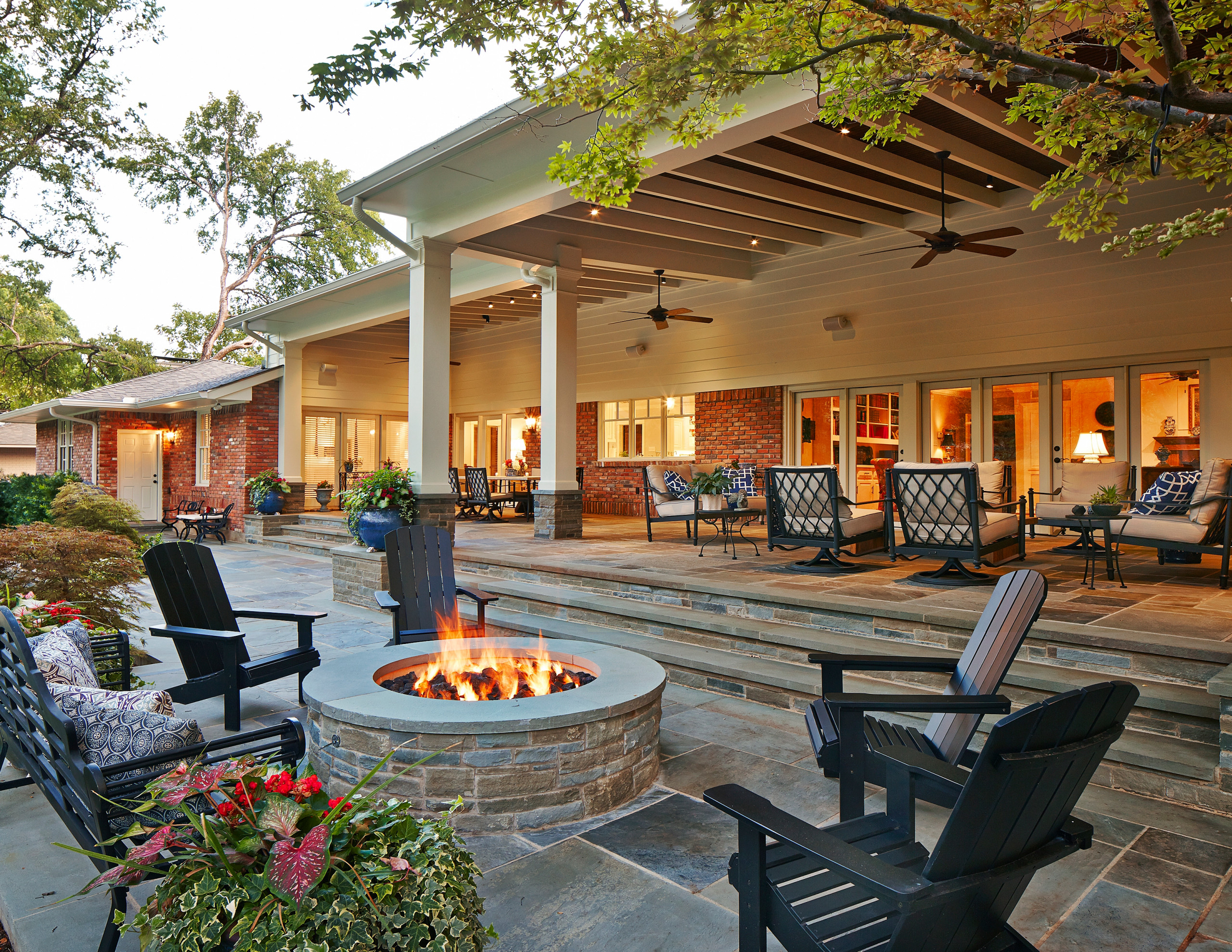 Spacious covered patio with fire pit, outdoor seating, and ceiling fans